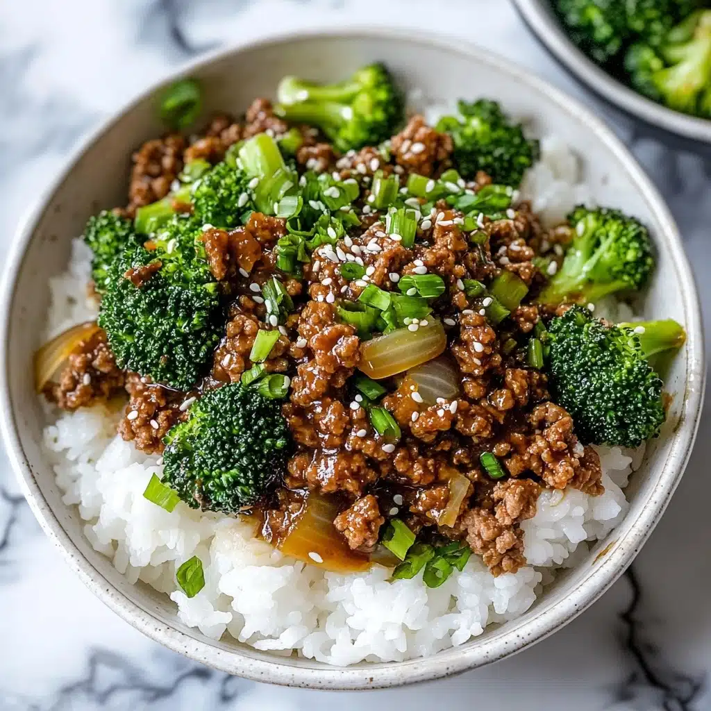 Ground Beef and Broccoli Stir Fry, easy ground beef stir fry, healthy broccoli stir fry, quick weeknight dinner, savory Asian beef stir fry A white speckled bowl on a white marbled surface holds a dish with three visible layers: the bottom layer is fluffy white rice with a slightly sticky texture, the middle layer is a mix of bright green broccoli florets and light brown cooked onions, and the top layer consists of dark brown cooked minced meat mixed with green chopped scallions and sprinkled with white sesame seeds. A silver fork rests inside the bowl on the right side. In the background, there are two small bowls, one filled with chopped green scallions and the other with sesame seeds.
