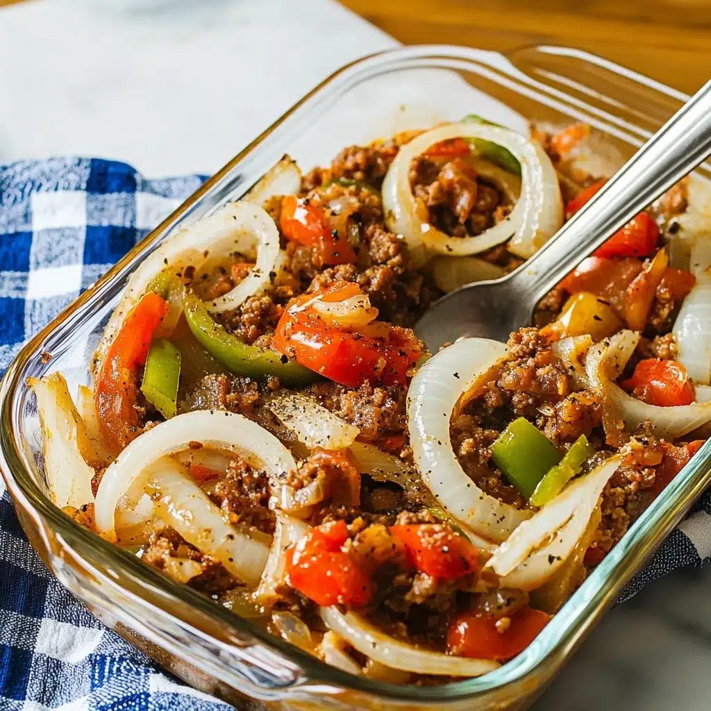 Dolly Parton's 5-Layer Dinner, hearty layered casserole, easy comfort food recipe, family-friendly baked dish, flavorful layered dinner The image shows a clear glass rectangular dish filled with layered food on a white marbled surface with a blue and white checkered cloth nearby. The bottom layer is brown, crumbly ground meat, topped with curved, translucent white onion slices sprinkled with black pepper or spices. On top of the onions, there are small, bright green pieces of pepper and chunked red tomato pieces scattered evenly. A large silver spoon stands inside the dish, ready to serve.