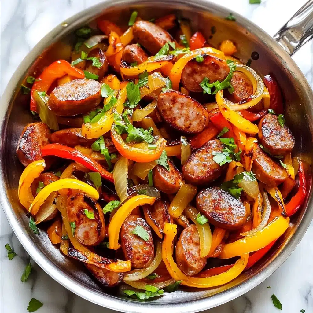 Sausage and Peppers Skillet, skillet sausage and peppers, quick sausage dinner, easy weeknight sausage recipe, one-pan sausage and peppers A close-up view of a silver pan filled with cooked sliced sausage rounds that are browned on the edges, mixed with long thin strips of red, yellow, and orange bell peppers, and translucent cooked onion slices. Fresh green herbs and chopped green onions are scattered over the top. The pan sits on a white marbled surface.
