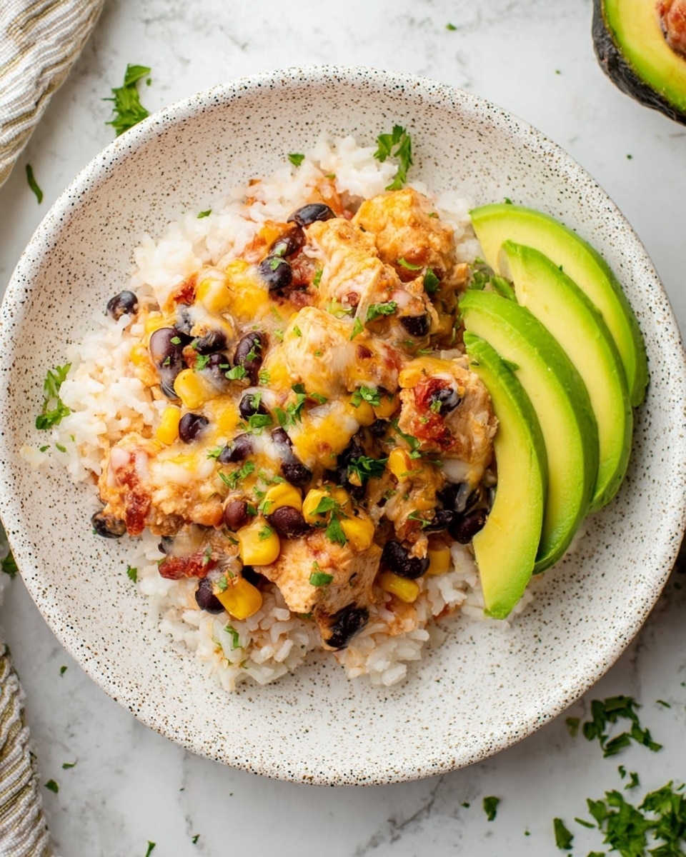 The dish is served on a white speckled plate with a base layer of white rice mixed with small bits of tomato. On top, there is a layer of cooked chicken pieces covered in melted cheese, black beans, and yellow corn, garnished with chopped green herbs. To the side of the chicken layer, there are three slices of fresh green avocado arranged in a fan shape. The plate is placed on a white marbled surface with a few scattered herbs around. photo taken with an iphone --ar 4:5 --v 7