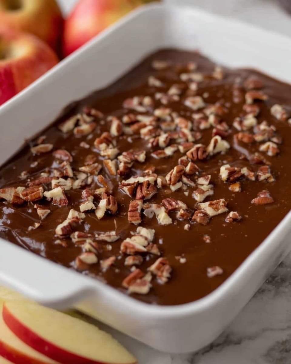 The image shows a close-up of a dessert with three visible layers. The top layer is smooth and shiny caramel with a rich brown color, sprinkled with roughly chopped pecans scattered evenly across the surface. Below this is a thick, creamy white layer, soft and fluffy in texture. The bottom layer, barely visible, is light and appears to have a crumbly or cake-like texture. A woman's hand is holding a spoon scooping some of the creamy middle layer and caramel from the dessert. The dessert is in a white dish, and the background is a white marbled surface. Photo taken with an iphone --ar 4:5 --v 7