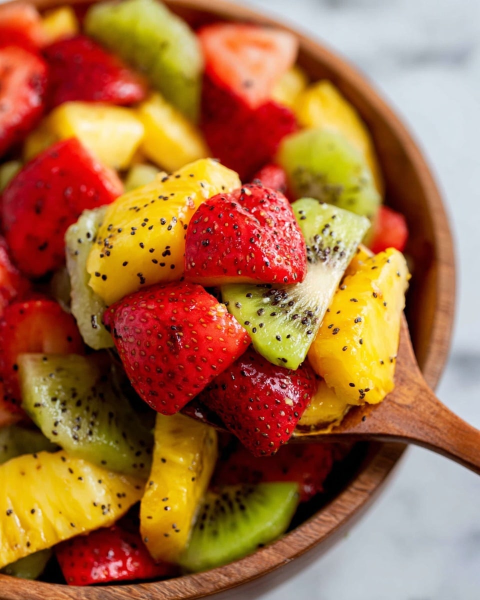 A close-up view of a colorful fruit salad in a wooden bowl with a wooden spoon lifting some fruit. The salad has multiple visible layers: bright yellow pineapple chunks at the bottom, next are pale green kiwi slices with black seeds, and on top are red strawberry pieces with their textured surface. The fruit pieces are sprinkled with tiny black seeds, evenly spread over the fruit, adding a speckled look. The background shows a white marbled texture. photo taken with an iphone --ar 4:5 --v 7