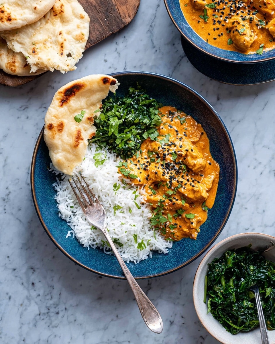 A white plate filled with thick orange curry with chunks of meat scattered throughout the sauce, sprinkled with small black seeds and topped with a few green leaves in the middle; a silver spoon rests on the right side of the plate, partially submerged in the curry. A woman's hand with red nail polish holds the plate on its left edge. Around the plate on a white marbled surface are three bowls: one with white rice at the top, one with bright green cooked spinach sprinkled with seeds on the right, and below a piece of light brown flatbread with darker toasted spots and a torn edge showing the soft inside. Photo taken with an iphone --ar 4:5 --v 7