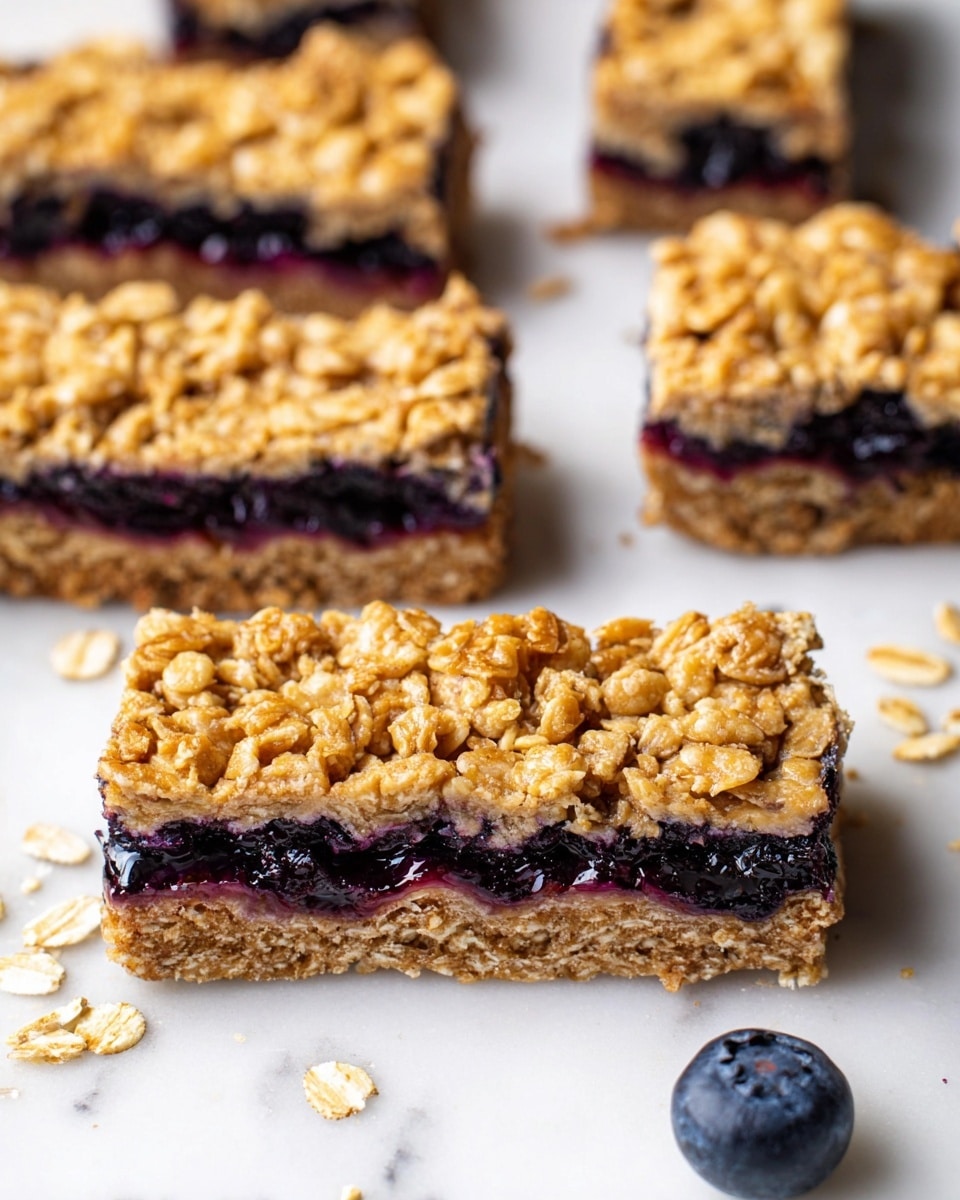 The image shows several rectangular oat bars arranged on a white marbled surface, each bar having three layers: the top layer is golden-brown oats with a rough texture, the middle layer is dark purple blueberry filling with a slightly glossy, juicy look, and the bottom layer is a dense, lighter brown oat base with visible oats throughout. The bars are thick and look chewy, with some loose oats scattered around them. Near the bottom right, there is a single fresh blueberry. The focus is sharp on the front bars, showing clear grain and fruit details. photo taken with an iphone --ar 4:5 --v 7