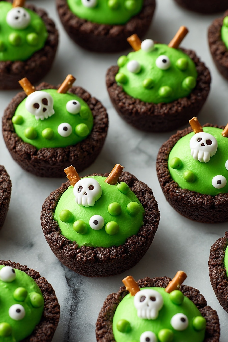 The image shows several dark brown cookie cups as the base layer, each with a thick, smooth, bright green frosting topped on them in a rounded mound shape. The green frosting is decorated with small white edible pearls, green candy balls, and white candy shapes like skulls and bones scattered across the surface. Some cookie cups have a single pretzel stick inserted vertically into the green frosting, adding a crunchy texture. All items are placed on a black tray with a close-up focus, and the background is a white marbled texture. photo taken with an iphone --ar 2:3 --v 7 - Cauldron Cookie Cups, Halloween Dessert Ideas, Fun Halloween Treats, Festive Cookie Cups, Easy Halloween Party Desserts