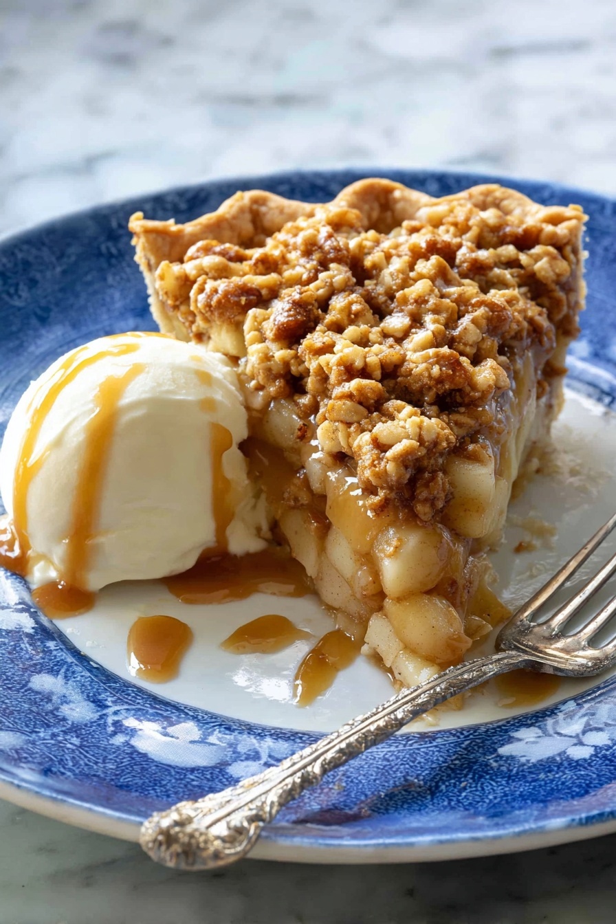 A slice of pie with three layers sits on a white plate with a blue pattern: the bottom is a light brown crust, the middle layer is soft apple chunks mixed with caramel sauce, and the top layer is a crumbly, golden brown oat topping with small pieces of nuts. Next to the pie is a scoop of white ice cream covered with caramel sauce. A silver fork with a twisted handle rests on the plate near the pie. The background has a white marbled texture. Photo taken with an iphone --ar 2:3 --v 7 - Apple Crisp Pizza, apple crisp dessert pizza, easy apple dessert, fruit pizza recipe, sweet pizza with apples