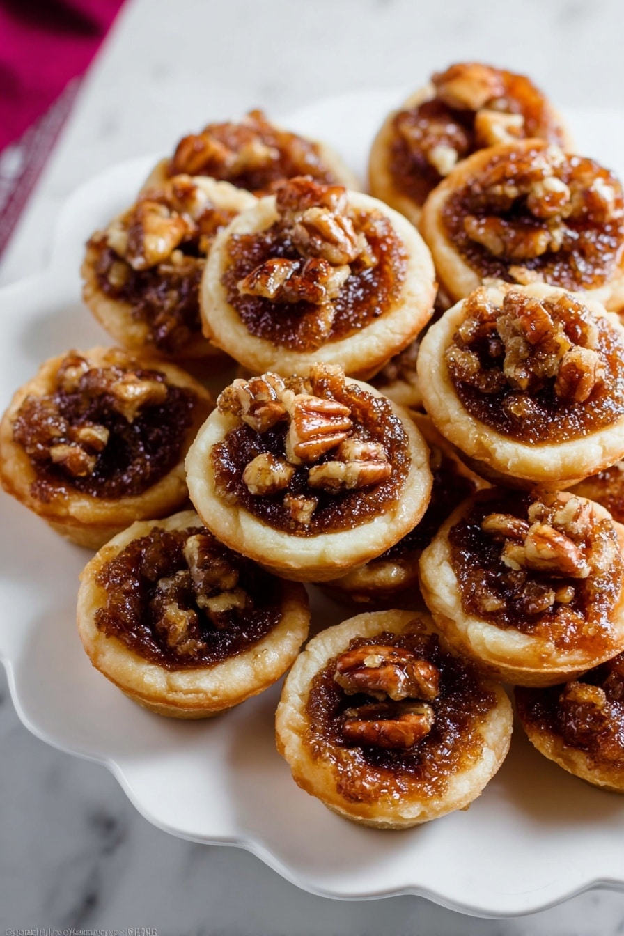 The image shows several small tartlets placed on a white marbled surface. Each tartlet has a golden-brown short crust base that looks crisp. Inside, there is a rich, bubbly filling made of dark brown caramelized nuts, mainly walnuts, giving a textured and slightly glossy look. The top layer is sprinkled with coarse white salt crystals, adding contrast and highlighting the nut filling. The tartlets are close together, showing a rustic and homemade feel with uneven edges and a warm, inviting color mix of golden crust and dark filling. photo taken with an iphone --ar 2:3 --v 7 - Mini Pecan Pies in a Muffin Pan, easy pecan pie bites, bite-sized pecan desserts, holiday pecan pie treats, pecan pie appetizer