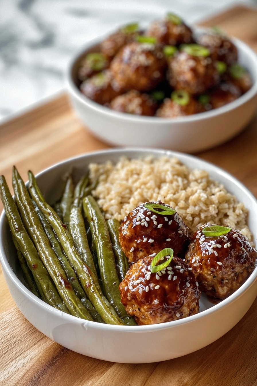 A white bowl contains three sections of food: on the left, a group of long, green roasted green beans with a slightly wrinkled texture; next to them at the bottom, a serving of light brown cooked rice with a soft, grainy look; on the right side, three round golden-brown meatballs covered with a shiny dark brown glaze, sprinkled with white sesame seeds and small green onion pieces on top. Behind this bowl, there is another white bowl filled with similar glazed meatballs, slightly blurred. Both bowls rest on a wooden surface with a white marbled texture background. Photo taken with an iphone --ar 2:3 --v 7 - Asian Glazed Turkey Meatballs, turkey meatballs with Asian glaze, easy Asian meatballs recipe, healthy turkey meatballs, quick dinner ideas