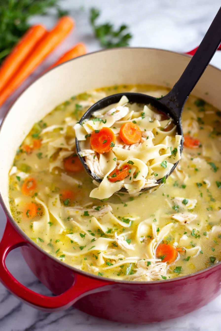 The image shows a red pot filled with chicken noodle soup placed on a white marbled surface. The soup has three main layers: a light yellow broth as the base with visible small green herbs scattered throughout; chunky pieces of white chicken and thick flat noodles spread evenly; and slices of orange carrot and green celery mixed in. A black ladle lifts a portion of soup, showing a close-up of a mix of chicken, noodles, carrot, and celery. In the background, there are some whole carrots and green parsley visible. Photo taken with an iphone --ar 2:3 --v 7 - Easy Chicken Noodle Soup, chicken noodle soup, quick chicken soup, comforting chicken soup, homemade chicken noodle soup