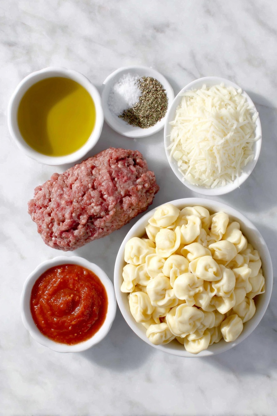 Flat lay of a small white ceramic bowl of golden olive oil, a handful of fresh lean ground beef, a small white ceramic bowl with diced white onion, three peeled garlic cloves, a small white ceramic bowl of crushed bright red tomatoes, a small white ceramic bowl of smooth red tomato sauce, a small white ceramic bowl containing dried Italian seasoning herbs, a small white ceramic bowl of kosher salt crystals, a small white ceramic bowl of freshly ground black pepper, a generous mound of fresh cheese tortellini pasta, and a small white ceramic bowl heaped with freshly grated mozzarella cheese, all arranged in perfect symmetry on a clean white marble surface, soft natural light, photo taken with an iPhone, professional food photography style, fresh ingredients, white ceramic bowls, no bottles, no duplicates, no utensils, no packaging --ar 2:3 --v 7 --p m7354615311229779997 - Baked Tortellini Casserole with Italian Cheese, creamy tortellini bake, cheesy Italian tortellini casserole, easy baked tortellini dishes, hearty cheesy pasta bake