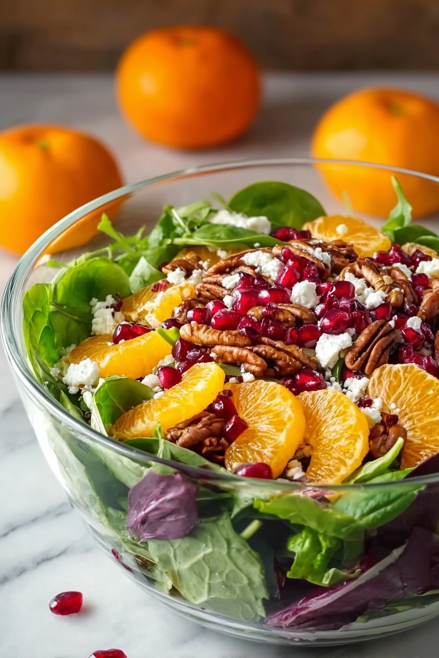 A clear glass bowl is filled with a colorful layered salad. The bottom layer is fresh green spinach and mixed greens with some purple leaves scattered in. On top, bright orange mandarin slices are placed evenly, along with deep red pomegranate seeds scattered around. There are also brown pecan halves spread throughout. Small white crumbles of cheese are sprinkled over the top, adding contrast. The bowl sits on a white marbled surface with two whole mandarins blurred softly in the background. The image has a natural light setting, highlighting the fresh and vibrant colors of the salad. Photo taken with an iphone --ar 2:3 --v 7 - Festive Citrus Pomegranate Salad, holiday citrus salad, easy holiday salad, fresh fruit holiday side dish, colorful holiday salad
