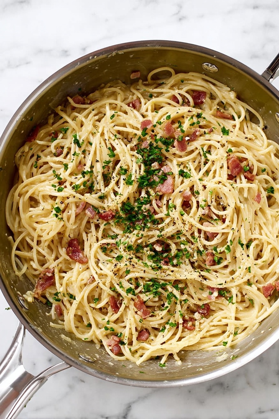 A silver metal pan filled with spaghetti noodles mixed with small pieces of reddish-brown bacon and finely chopped green parsley sprinkled on top. The pasta has a light cream sauce coating, and tiny black pepper bits are scattered throughout. The pan is placed on a white marbled surface. Photo taken with an iphone --ar 2:3 --v 7 - Easy Spaghetti Carbonara, classic Roman pasta dish, simple Italian pasta recipe, quick dinner ideas, creamy carbonara sauce