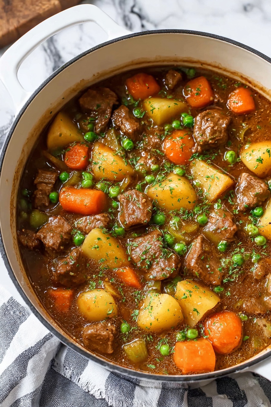 A white pot filled with a thick stew showing several layers: large chunks of brown meat, round orange carrot slices, yellow potato pieces, small green peas, and diced celery, all mixed in a rich brown sauce and lightly sprinkled with chopped green herbs on top. The pot sits on a white marbled surface with a striped gray and white cloth partially visible underneath. The colors of the stew ingredients contrast brightly with the white pot, making the dish look warm and hearty photo taken with an iphone --ar 2:3 --v 7 - Hearty Beef Stew, best beef stew recipes, easy beef stew, comforting beef stew, tender beef stew