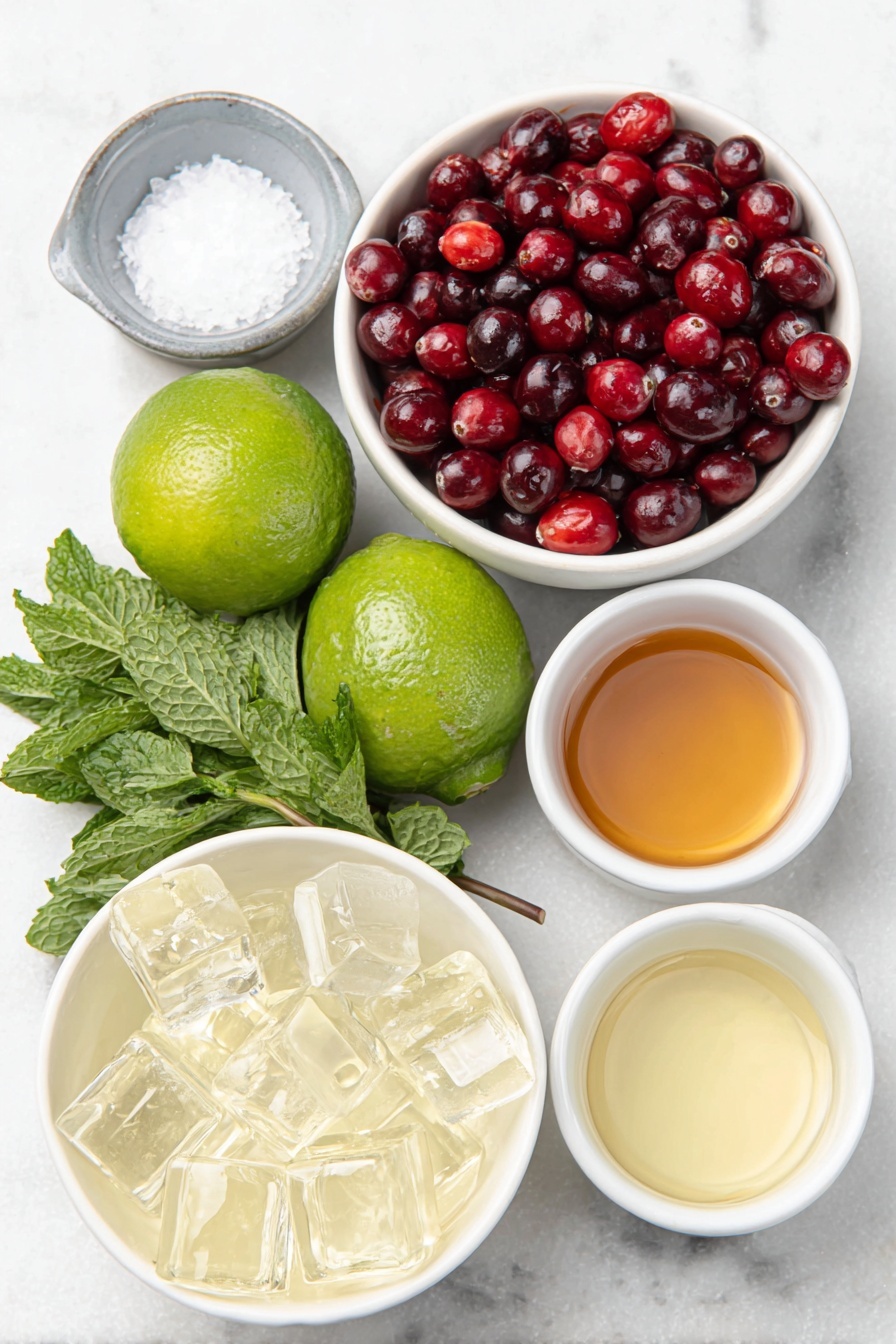 Flat lay of fresh green lime wedges, whole bright red cranberries, a few sprigs of vibrant fresh mint leaves, coarse crystals of salt in a small white ceramic bowl, clear ice cubes arranged neatly, and small white ceramic bowls each filled with pale golden tequila blanco, clear triple sec, fresh pale green lime juice, deep red cranberry juice, and light amber simple syrup, all ingredients naturally fresh and arranged in perfect symmetry on a clean white marble surface, soft natural light, photo taken with an iPhone, professional food photography style, fresh ingredients, white ceramic bowls, no bottles, no duplicates, no utensils, no packaging --ar 2:3 --v 7 --p m7354615311229779997 - Mistletoe Margarita with Cranberry and Lime, festive margarita drink, holiday cocktail recipe, Christmas margarita, cranberry lime cocktail